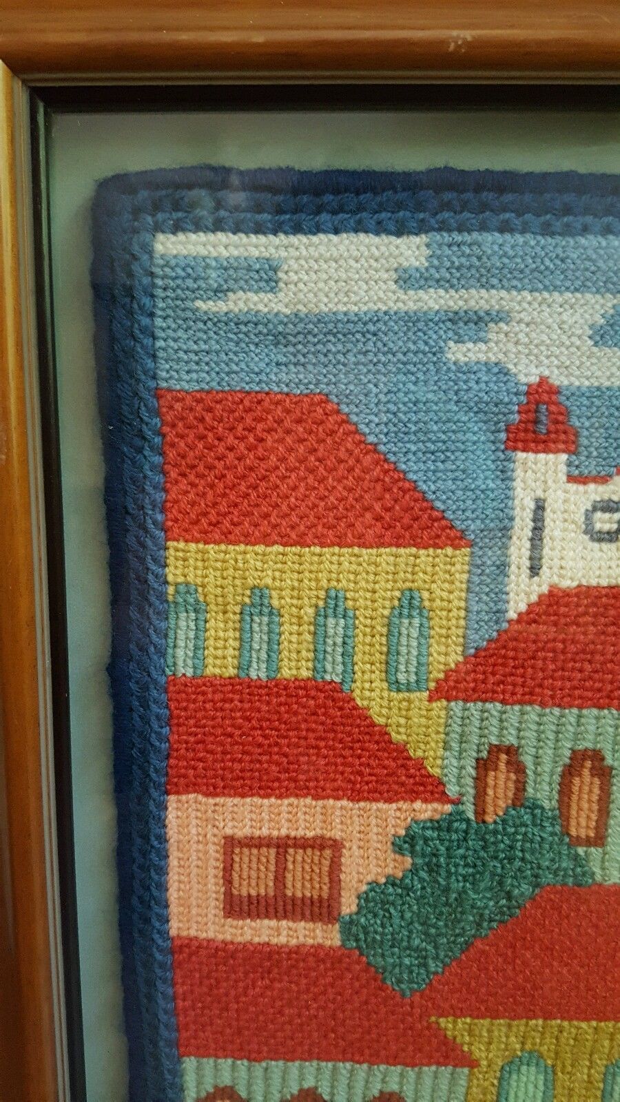 Framed needlepoint knitting artwork of  church and buildings skyline