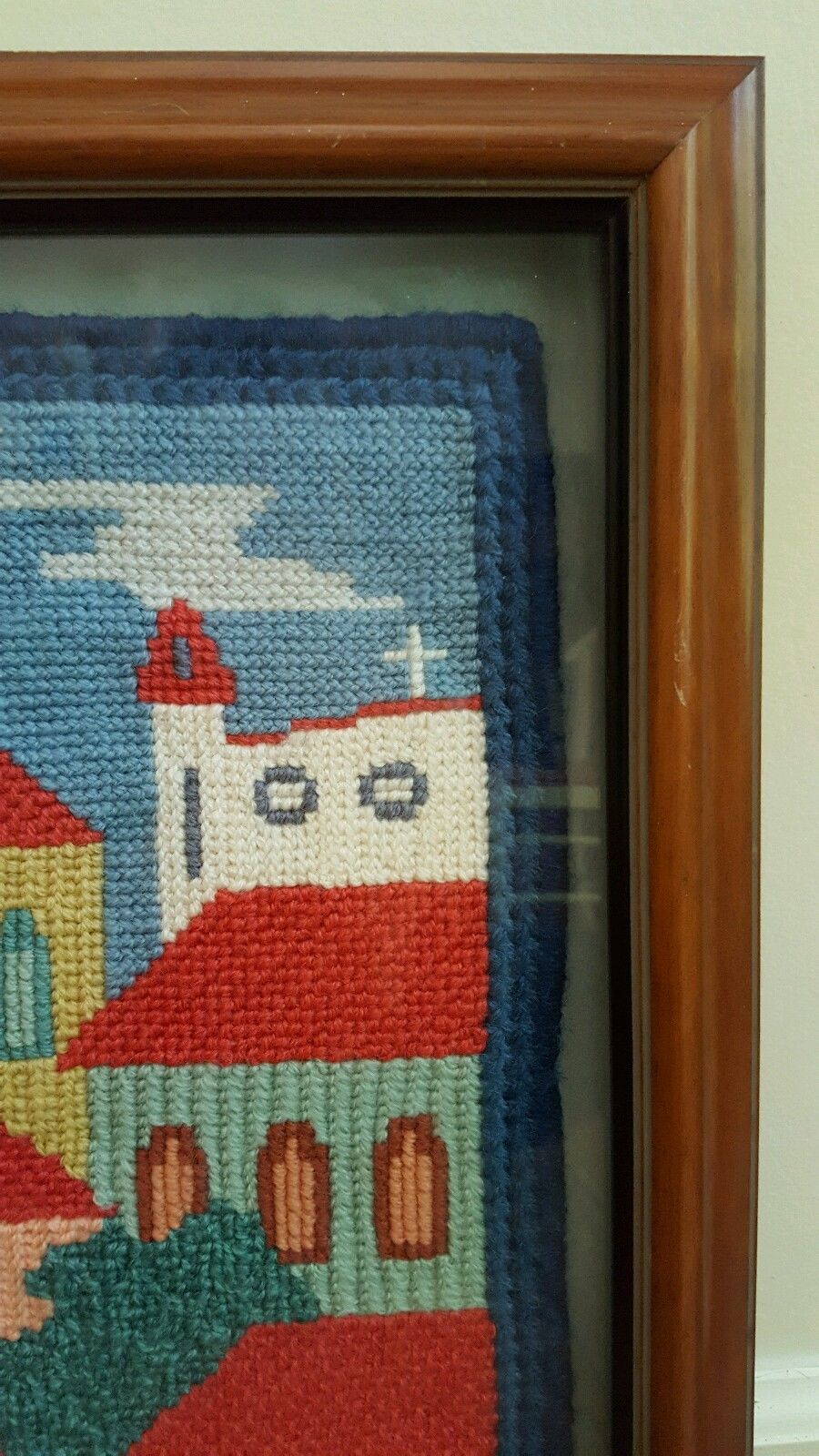 Framed needlepoint knitting artwork of  church and buildings skyline