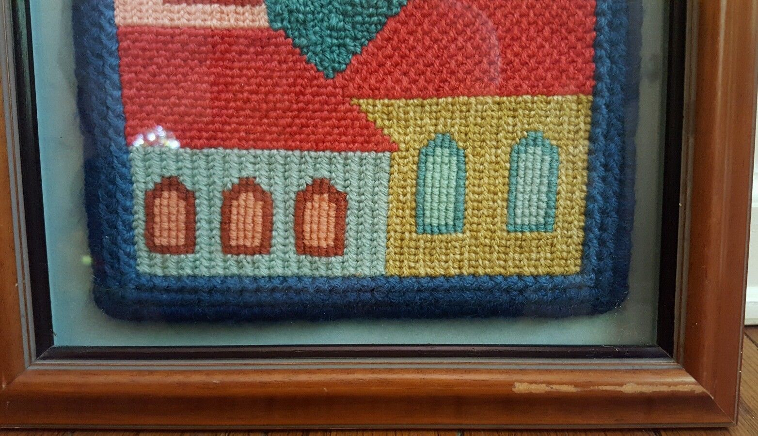 Framed needlepoint knitting artwork of  church and buildings skyline